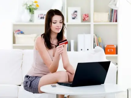 Woman with credit card and laptop at home