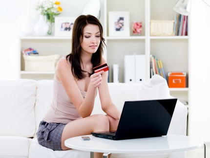 Woman with credit card and laptop at home